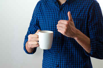 Close up of a man holding a coffee or tea cup