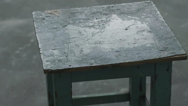 Slow motion handheld shot of old stool in empty room during renovation