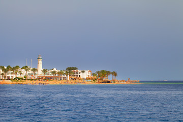 Seashore view with building and small tower on the beach