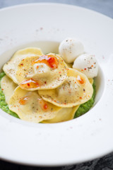 Closeup of a white plate with italian ravioli, selective focus, shallow depth of field