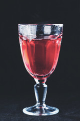 Fruit fresh hot drink in high glass on dark background, toned image