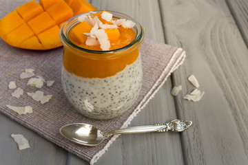 Pudding with chia,mango and coconut chips on the grey napkin