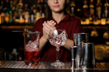 Female bartender making final actions with the cocktail