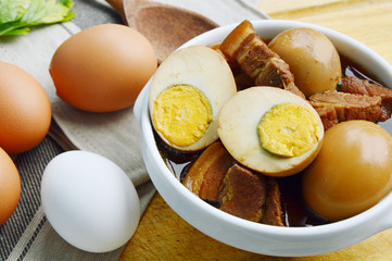 Eggs Stewed or Thai name is khai phalo muu saam chan on wooden background