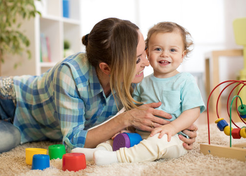 Mother in living room playing with smiling baby boy
