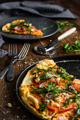 Pizza with arugula, tomatoes and feta cheese
