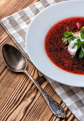 Borscht on a wooden table with garlic