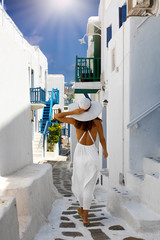 Frau im weißen Kleid erkundet Mykonos Stadt mit den weißgewaschenen Häusern und Gassen,...