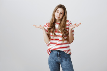 I do not care about rules. Portrait of indifferent careless teenage girl with blonde hair shrugging...