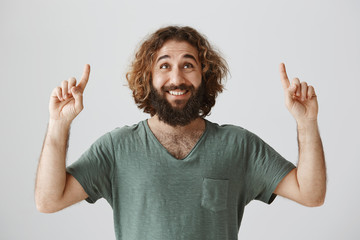 Guy is confessing in love under girlfriend balcony. Portrait of cheerful attractive eastern guy...