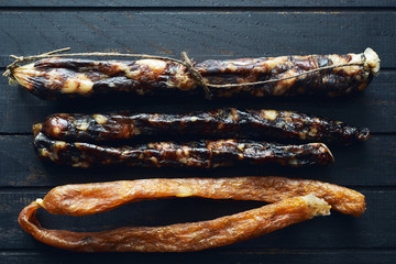 Delicious different homemade sausages in wooden table top view 