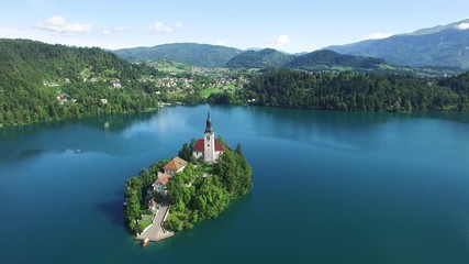 AERIAL VIEW: flight over Lake Bled in Slovenia .Top View of the Church of the Assumption of the Virgin Mary
