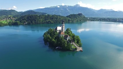 AERIAL VIEW: flight over Lake Bled in Slovenia .Top View of the Church of the Assumption of the Virgin Mary
