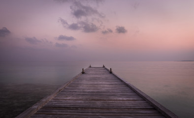 Fototapeta na wymiar Wooden jetty and amazing sunrise in Maldives