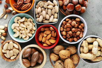 mixed nuts on grey background. Healthy food and snack. Walnut, pecan, almonds, hazelnuts and cashews.