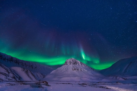 The polar arctic Northern lights aurora borealis sky star in Norway Svalbard in Longyearbyen city man mountains