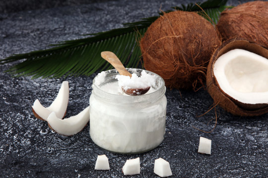 coconut oil and fresh coconuts on grey background.