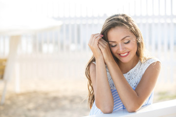Fototapeta premium Portrait of Young stylish beautiful woman in blue printed dress on the beach