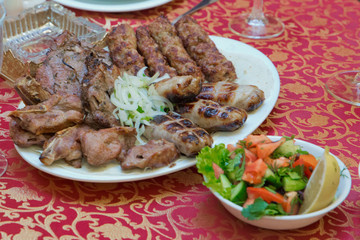 Meat kebab inside the stove. Steak kebab. Salad . Chopped onion . Chopping kebab . Shashlyk . Kiebab .