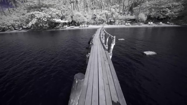 Walking a pier towards an island in Cambodia. Koh Tonsay (Rabbit Island). Shot in infrared.