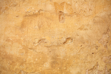 Weathered yellow painted wall background, partially faded