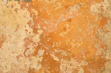 Detail of an old rough wall with orange color layers suitable as a background
