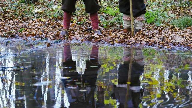 Cinemagraph - Medieval Vikings reflected in water. Beech forest. Medieval Reenactment. Vikings are with swords and battle ax in hands. Dressed in chain mail. Medieval Reenactment.