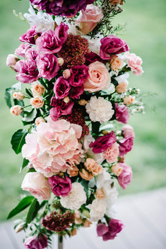 Compositions of flowers decorated with pink hydrangeas, roses, white carnations and greens, which is located stands on arch for wedding ceremony. wedding decor.