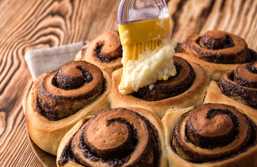 Female hand covers cream pastry with a bun roll