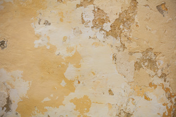 Old yellow painted wall background, partially faded