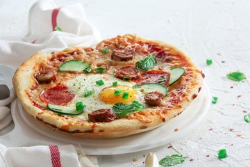 Homemade breakfast Pizza with fried egg pepperoni and veggies