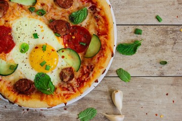 Homemade breakfast Pizza with fried egg pepperoni and veggies