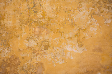 Weathered yellow painted wall background, partially faded
