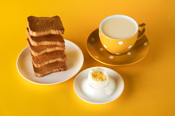 Healthy breakfast with flying toasts, cup of fresh milk with chicken egg on yellow background. Levitation food, diet, vegetarian food concept.