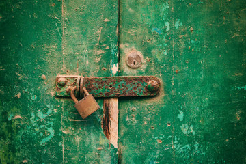 Locked door. Closed old rusty padlock on a distressed wooden door