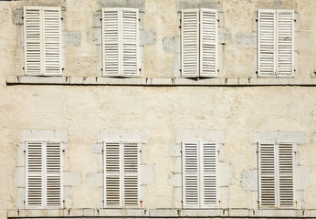  house facade with eight closed shutters in white