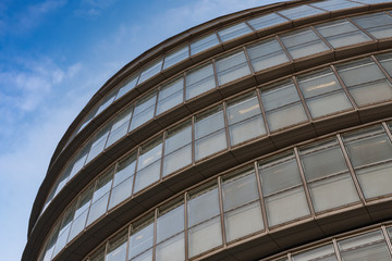 Roof and glass facade of modern skyscraper, blue sky on background