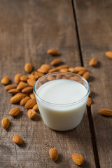 glass of almond milk on wooden surface