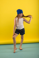 Beautiful caucasian girl posing in studio on a Yellow background