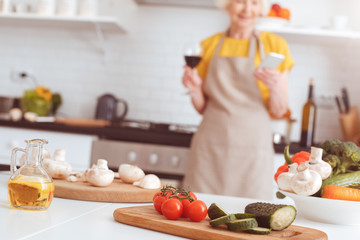 Finely sliced ingredients for salad, blurry background with grandmother