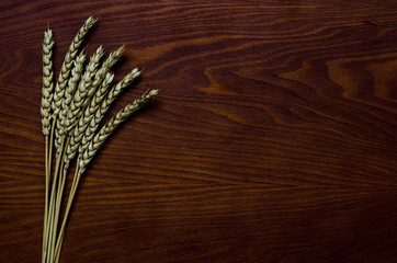 Wheat on dark wooden surface background texture