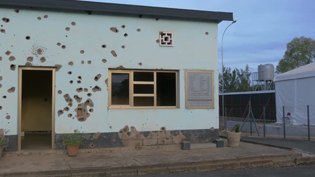 Bullet holes on wall in Kigali Camp