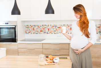 Pregnant woman preparing meal, vegetables, and drink milk