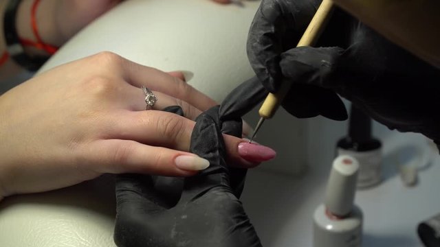 Beauty saloon. Nail salon. The manicurist does a manicure to a girl. Close-up. 4K.