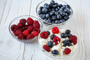 healhty breakfast or meal on white wooden table with cottage cheese and berries