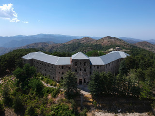 Aerial view of abandoned stonebuilt hotel on the mountains
