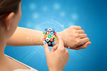 Hand with smartwatch and application symbols nearby.