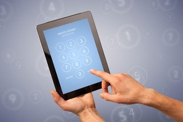Female fingers touching tablet with locked device requiring passcode
