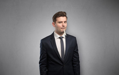 Young tired businessman with thermometer and copy space
