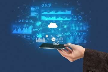Businessman using phone with flying application icons around
